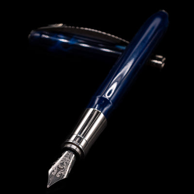 Visconti Rembrandt Blue Fountain Pen - Preowned laying across its own cap, crossed, with a focus on the nib.