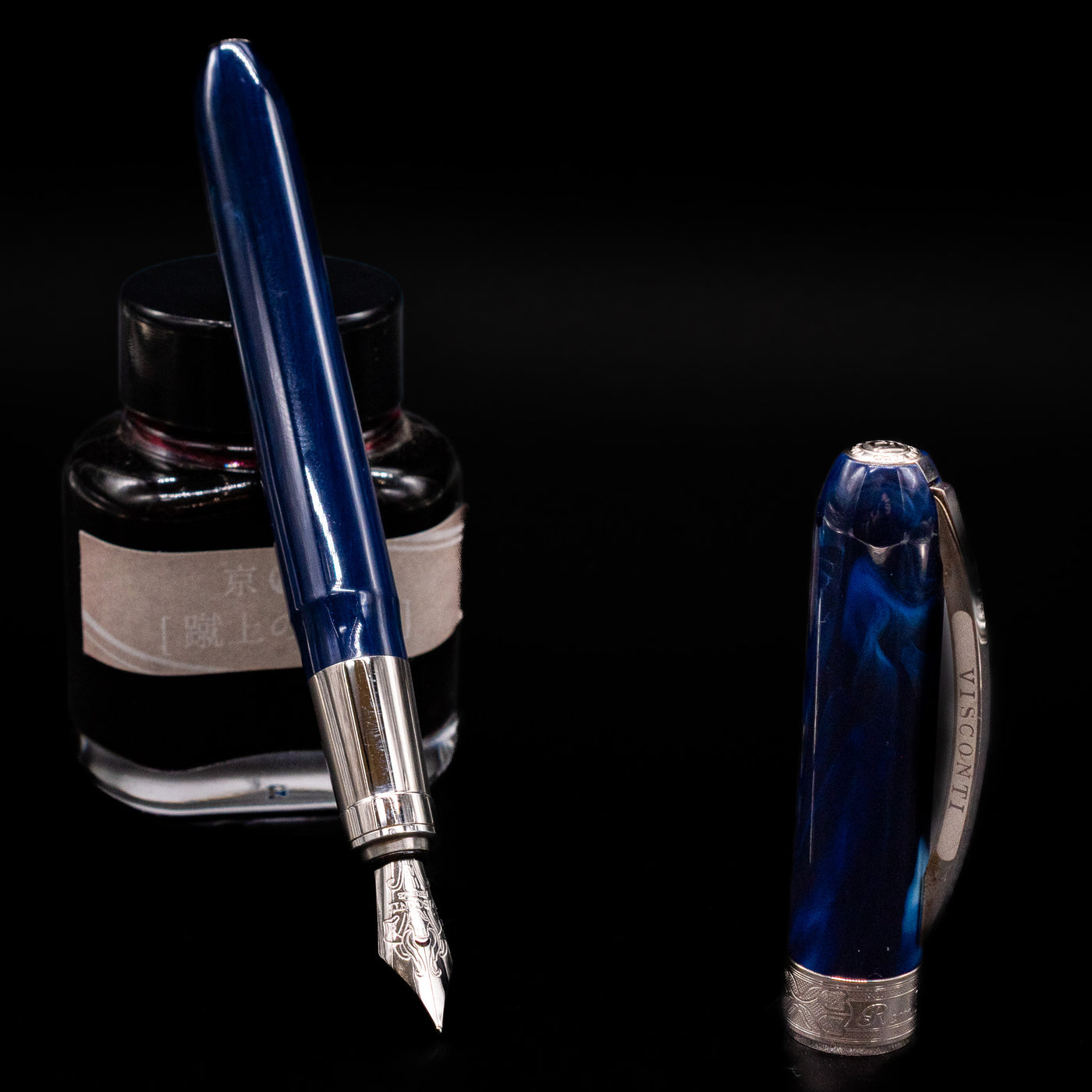 Visconti Rembrandt Blue Fountain Pen - Preowned leaning on an ink bottle uncapped showcasing the detailing on the nib.