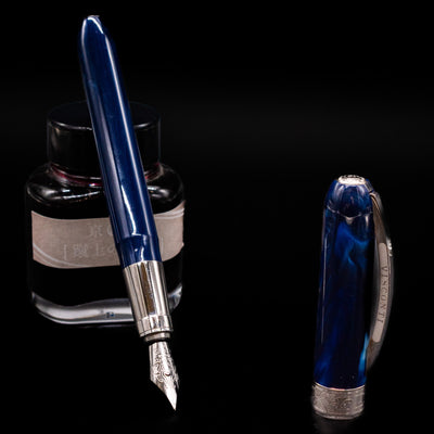 Visconti Rembrandt Blue Fountain Pen - Preowned leaning on an ink bottle uncapped showcasing the detailing on the nib.
