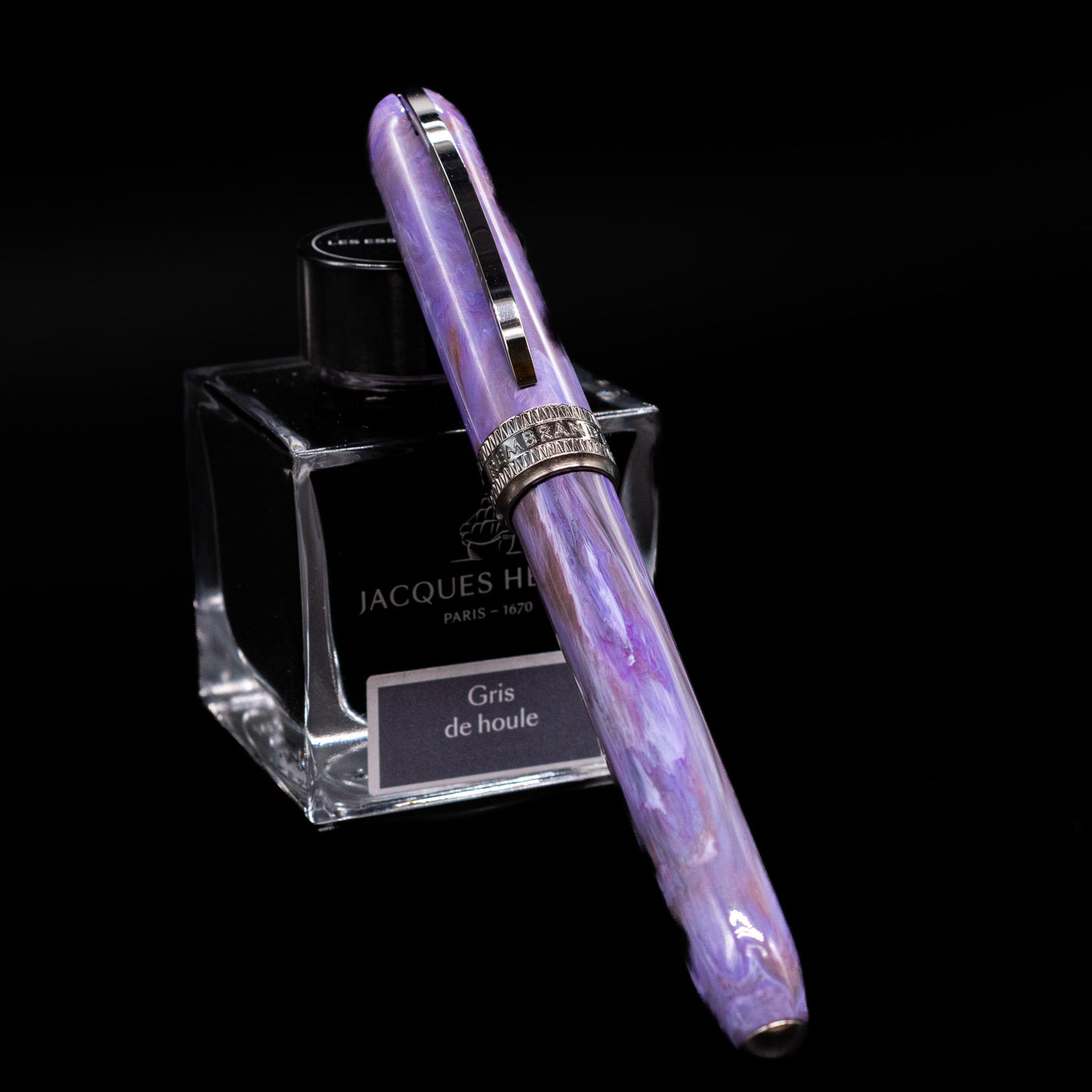 Visconti Rembrandt S Fountain Pen - Lavender capped, leaning against an ink bottle. 