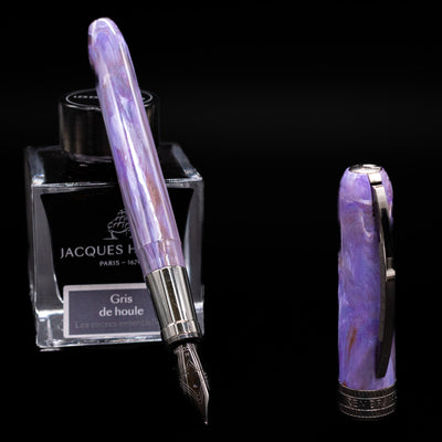 Visconti Rembrandt S Fountain Pen - Lavender leaning on an ink bottle uncapped showcasing the detailing on the nib.