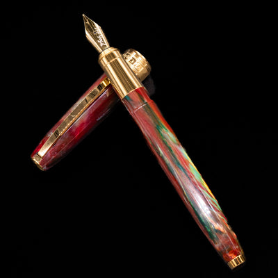 Visconti Van Gogh Fountain Pen - Flowering Plum Orchard laying on top of its cap in a crossed position showing full view of the entire uncapped pen.