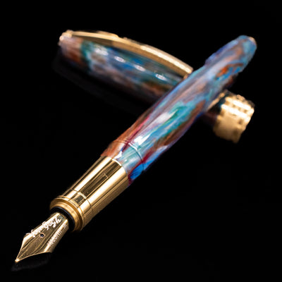 Visconti Van Gogh Fountain Pen - Oiran laying across its own cap, crossed, with a focus on the nib.