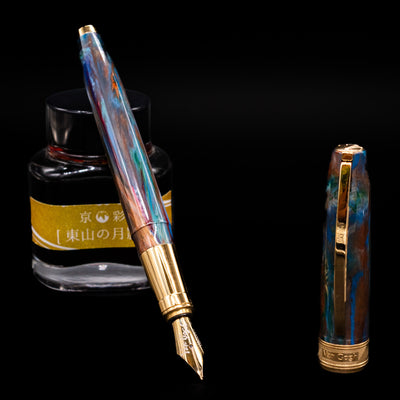 Visconti Van Gogh Fountain Pen - Oiran  leaning on an ink bottle uncapped showcasing the detailing on the nib.