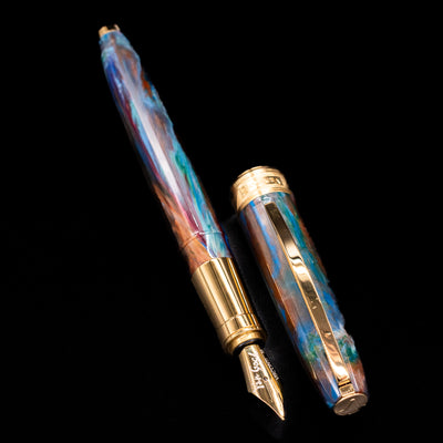 A full view of the Visconti Van Gogh Fountain Pen - Oiran uncapped, with its cap laying next to the pen. 