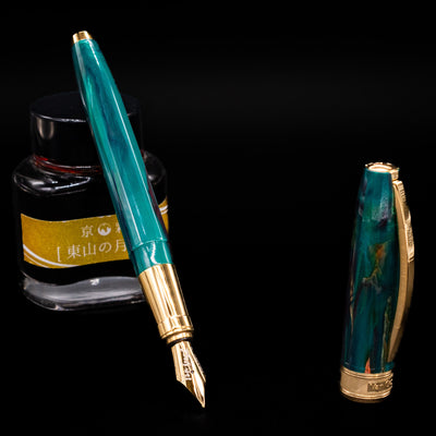 Visconti Van Gogh Fountain Pen - The Novel Reader leaning on an ink bottle uncapped showcasing the detailing on the nib.