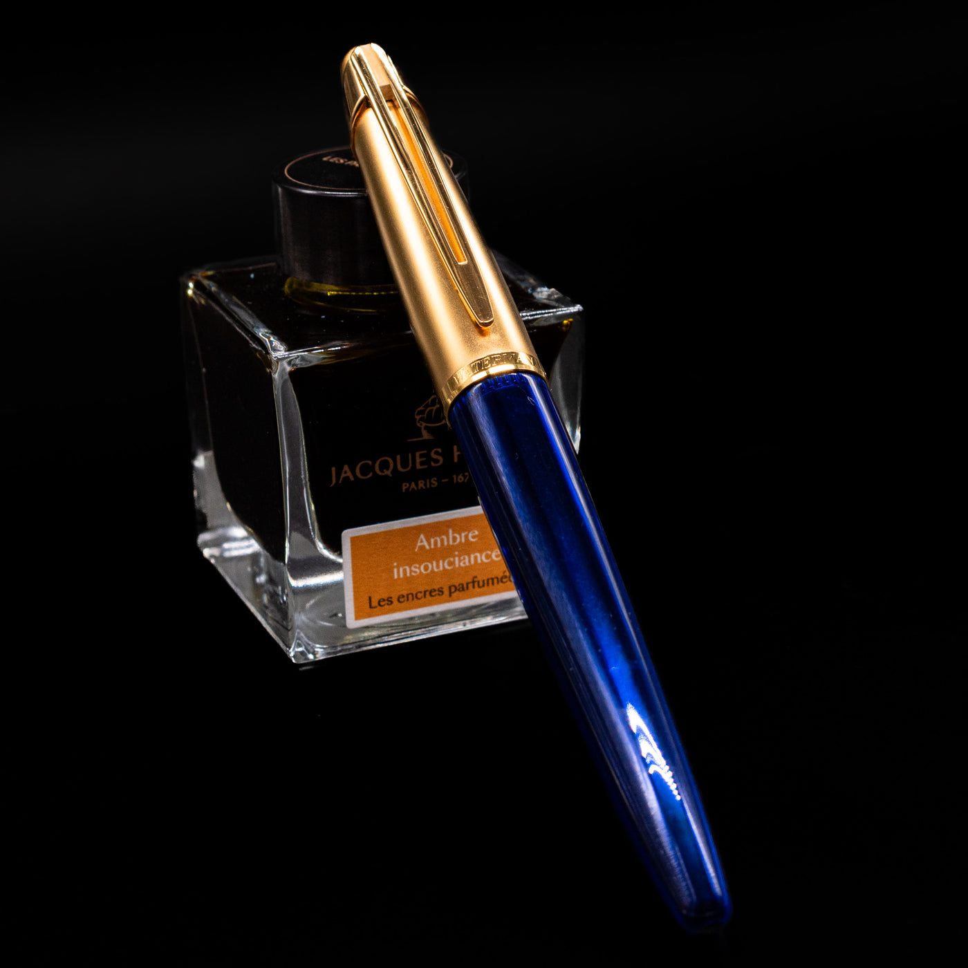Waterman Edson Sapphire Fountain Pen - Preowned capped, leaning against an ink bottle. 