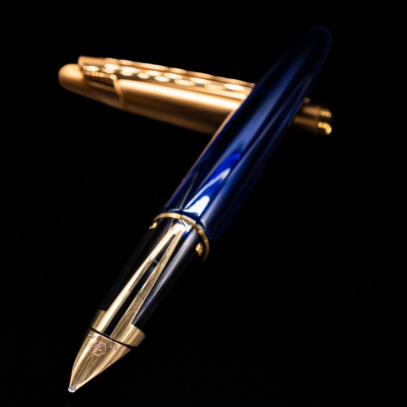 Waterman Edson Sapphire Fountain Pen - Preowned laying across its own cap, crossed, with a focus on the nib.