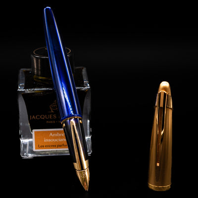 Waterman Edson Sapphire Fountain Pen - Preowned leaning on an ink bottle uncapped showcasing the detailing on the nib.