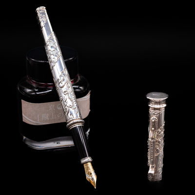 Yard O Led Imperial Dragon Fountain Pen - Preowned leaning on an ink bottle uncapped showcasing the detailing on the nib.