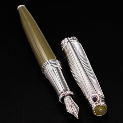Caran d'Ache Leman Terre d'Ombre Fountain Pen and silver cap positioned side by side on black background