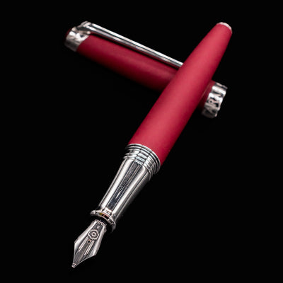 Burgundy Léman V2 fountain pen with nib angled toward the camera, resting on cap