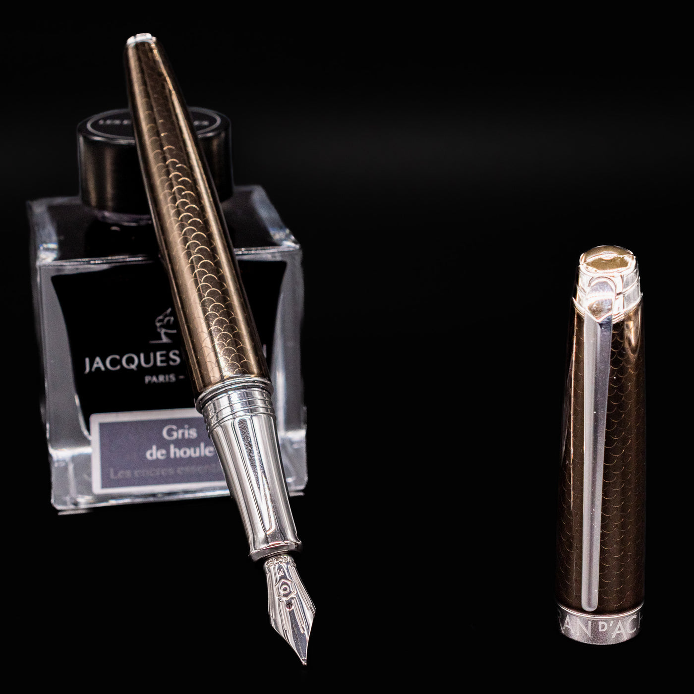 Uncapped Léman V2 Caviar pen resting on ink bottle