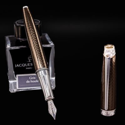 Uncapped Léman V2 Caviar pen resting on ink bottle