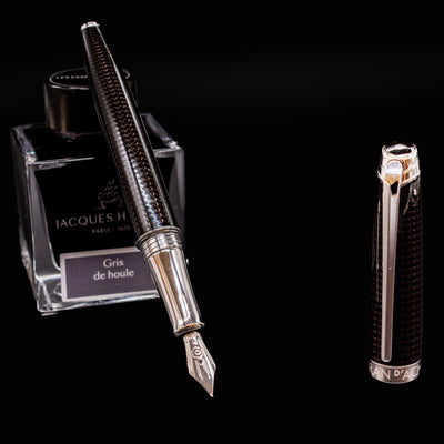 Caran d’Ache Léman V2 De Nuit fountain pen, uncapped and resting on ink bottle