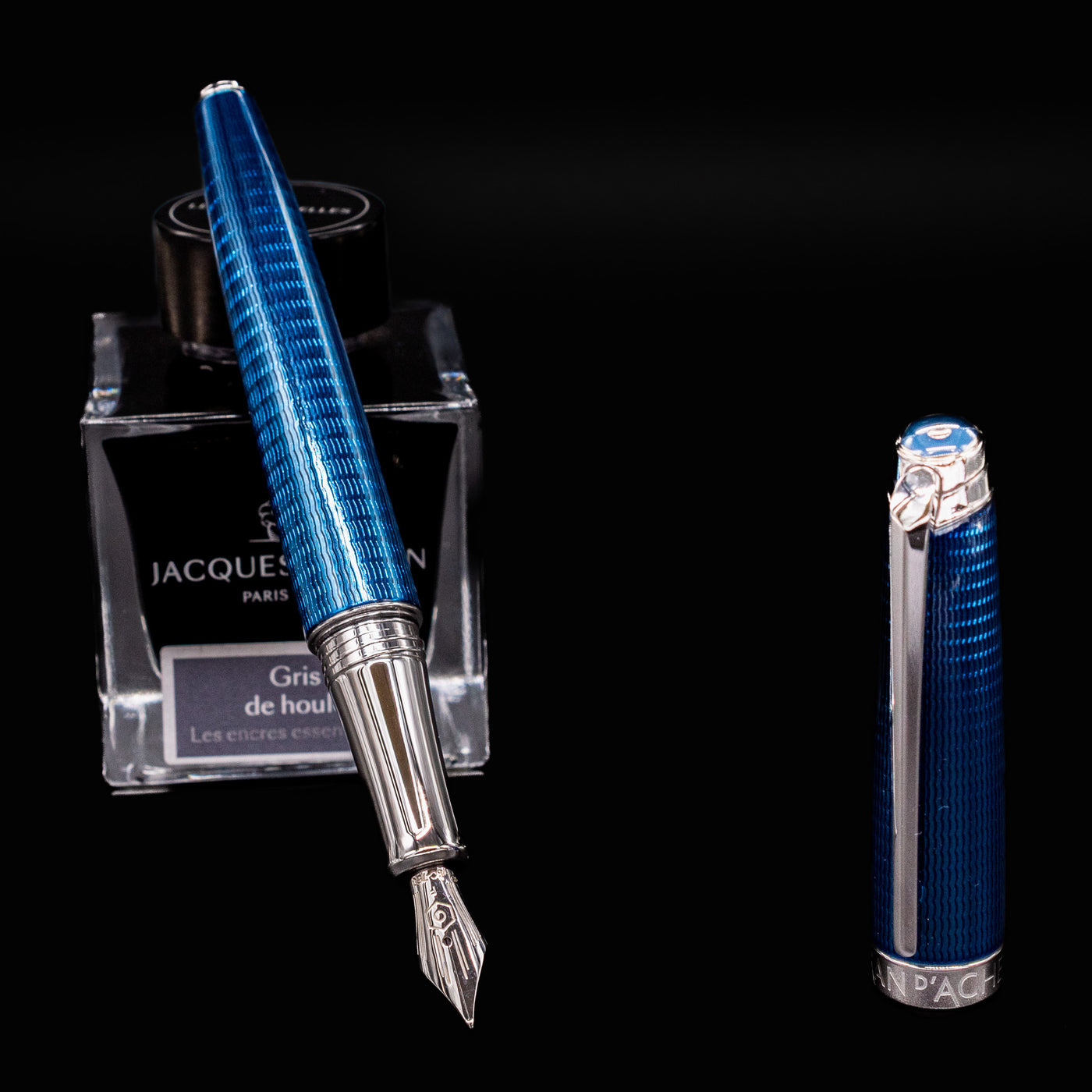 Uncapped Grand Bleu fountain pen resting on an ink bottle