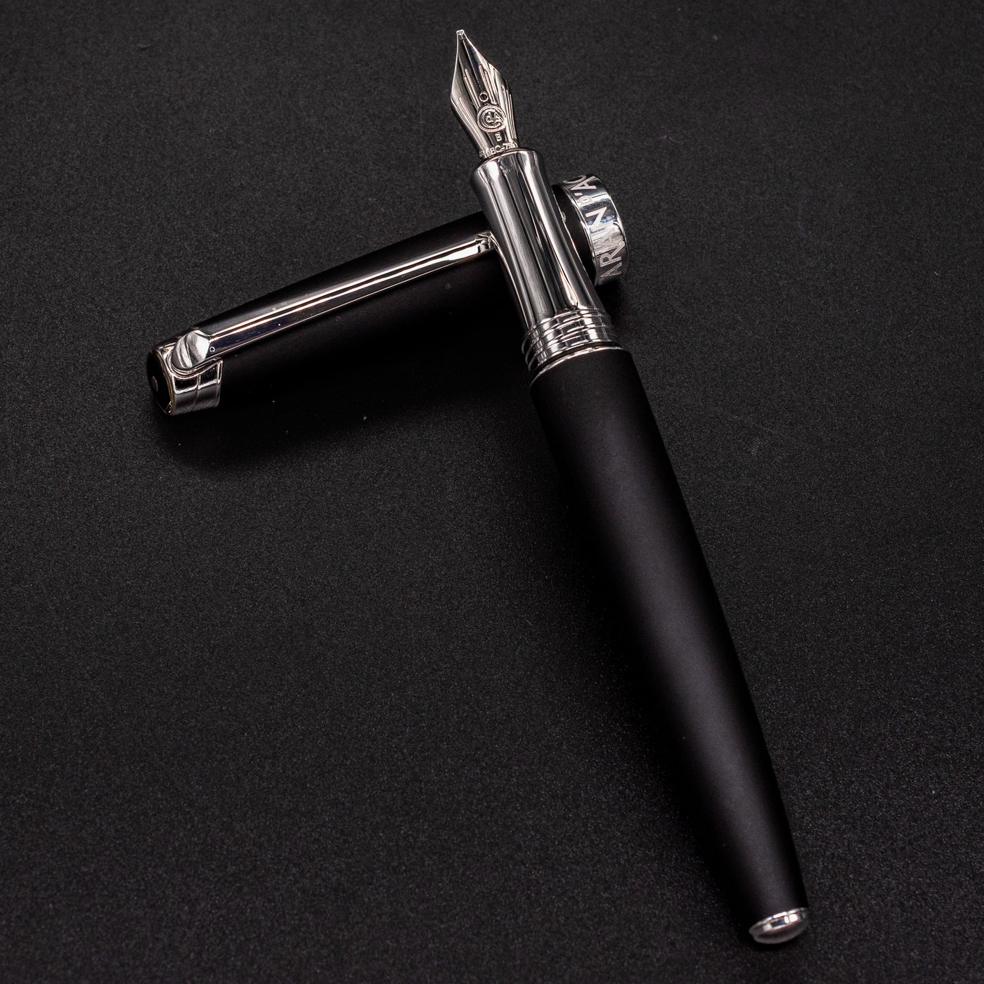 Overhead view of uncapped Léman V2 Matte Black pen resting on cap