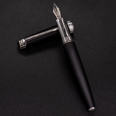 Overhead view of uncapped Léman V2 Matte Black pen resting on cap