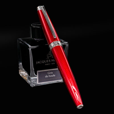 Léman V2 Rouge Carmin fountain pen, capped and resting on ink bottle