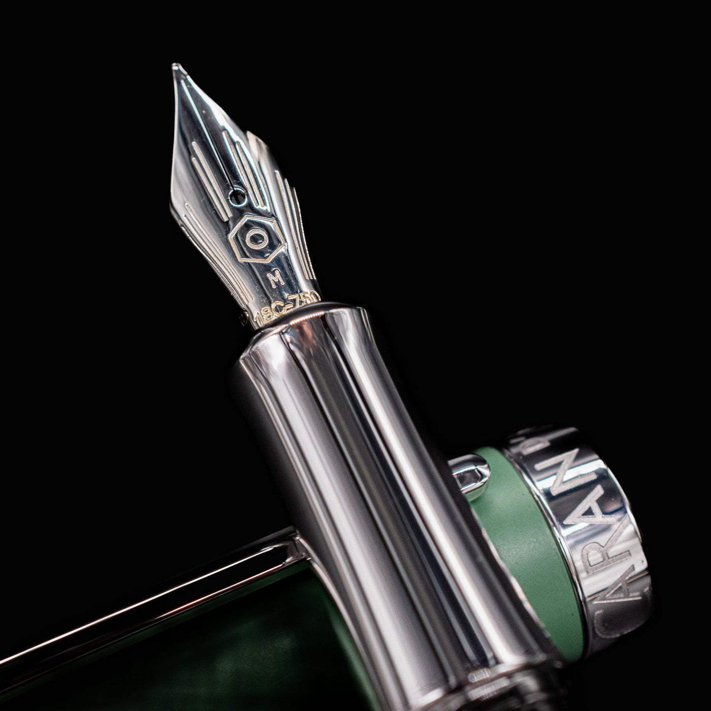 Detailed closeup of the hand-polished 18k rhodium-coated gold nib on the Caran d’Ache Léman V2 fountain pen.

