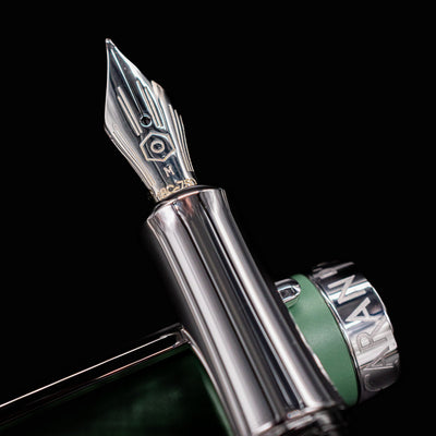 Detailed closeup of the hand-polished 18k rhodium-coated gold nib on the Caran d’Ache Léman V2 fountain pen.

