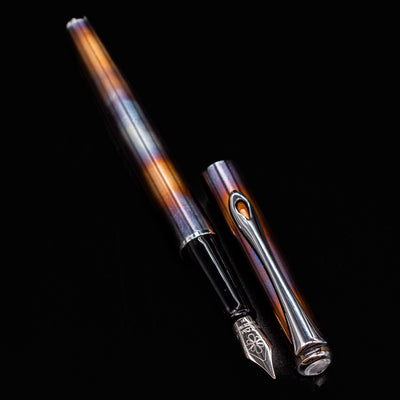 Diplomat Traveller Flame pen cap and barrel resting side by side, displaying the unique heat-treated finish