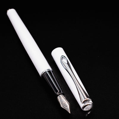 Diplomat Traveller White & Chrome Fountain Pen with cap removed and lying side by side on black background