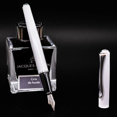 Uncapped Diplomat Traveller White & Chrome Fountain Pen with nib exposed, displayed beside Jacques Herbin ink