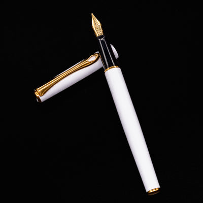 Flat lay of the Diplomat Traveller White & Gold Fountain Pen with cap off