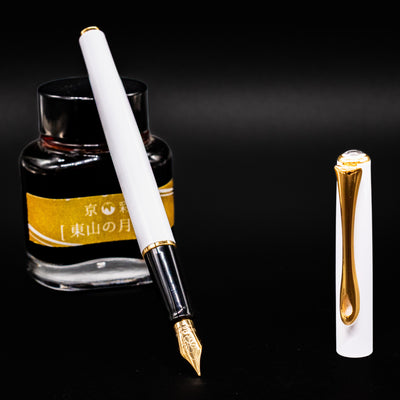 Diplomat Traveller White & Gold Fountain Pen uncapped and standing upright with cap beside it