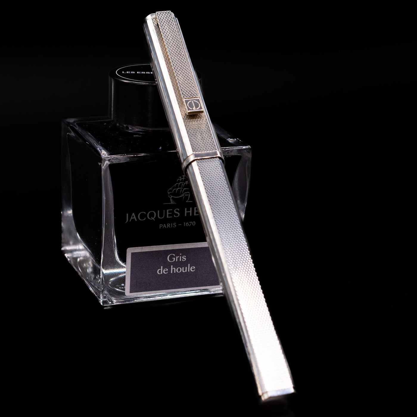 Capped Dunhill Gemline Classic Dress Sterling Silver Fountain Pen leaning on Jacques Herbin Gris de Houle ink bottle