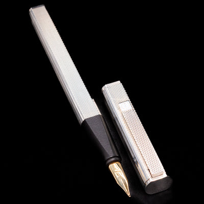 Open Dunhill Gemline Sterling Silver Fountain Pen with cap lying beside on black background