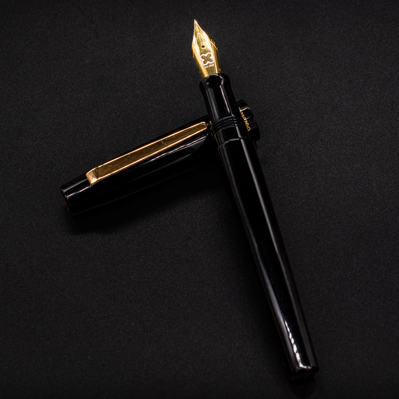 Esterbrook Camden Black & Gold fountain pen body resting on cap - elegant black and gold design