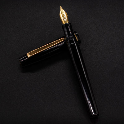 Esterbrook Camden Black & Gold fountain pen body resting on cap - elegant black and gold design
