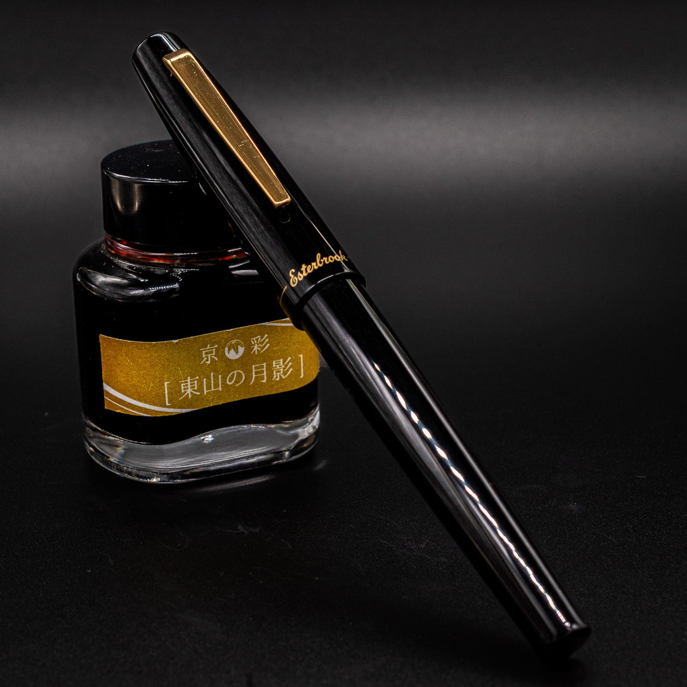 Esterbrook Camden Black & Gold fountain pen capped leaning on ink bottle - classy and modern design