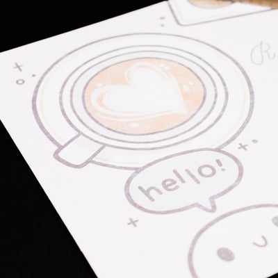 Close-up of heart-shaped latte art and “hello!” bubble on the Esterbrook x TheCoffeeMonsterzCo blotter paper design.