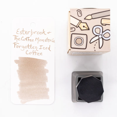 Top-down view of Esterbrook x TheCoffeeMonsterzCo Forgotten Iced Coffee Ink Bottle, ink swab, and gift-style box.