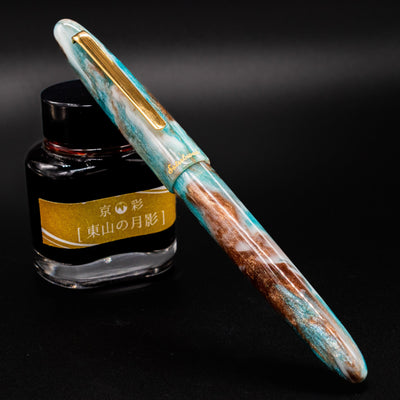 Esterbrook Estie Avalanche fountain pen capped leaning on ink bottle - seasonal limited edition pen