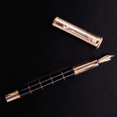 Flat lay of the Graf von Faber-Castell Classic Anello Rose Gold fountain pen with the cap placed separately.