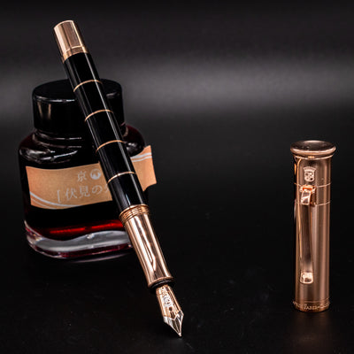 Graf von Faber-Castell Classic Anello Fountain Pen in Rose Gold finish, uncapped with nib facing up, displayed next to ink bottle.