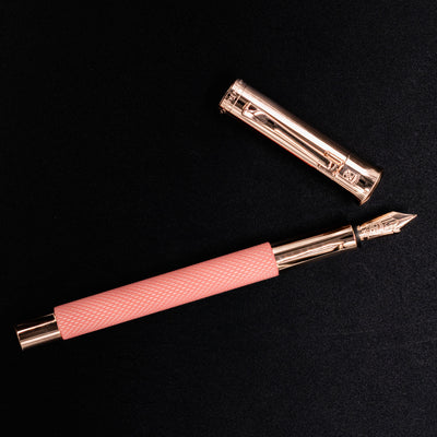 Overhead flat lay of Graf von Faber-Castell Guilloche Fountain Pen - Rose with cap to the side