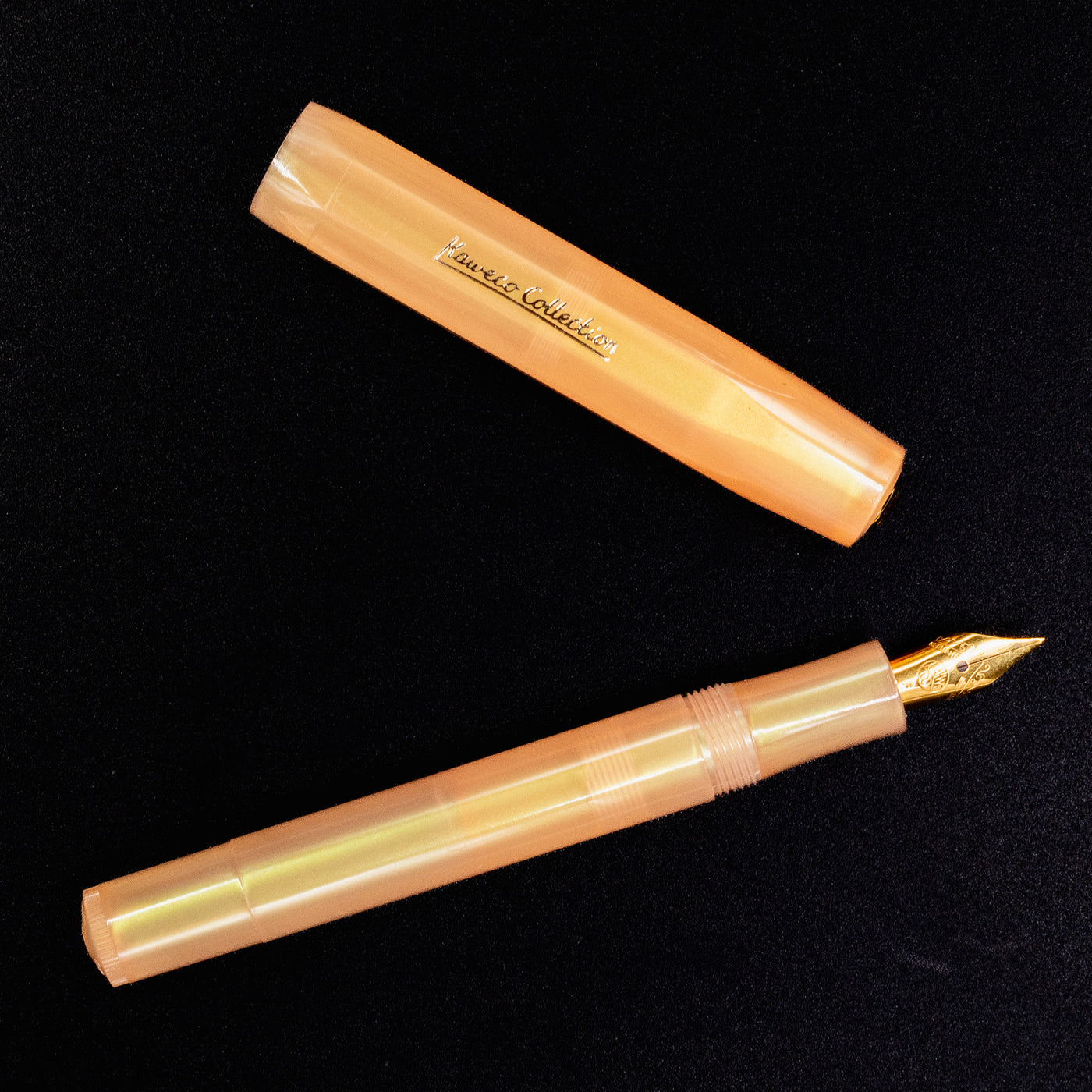 Flatlay image of the Kaweco Apricot Pearl fountain pen and cap, highlighting pearlescent barrel and compact design.