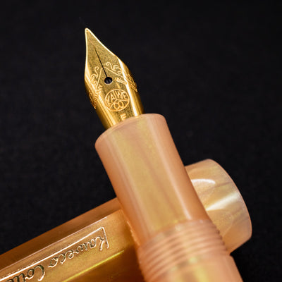 Macro shot of the gold-plated nib on the Kaweco Apricot Pearl fountain pen, engraved with the Kaweco logo and scrollwork.