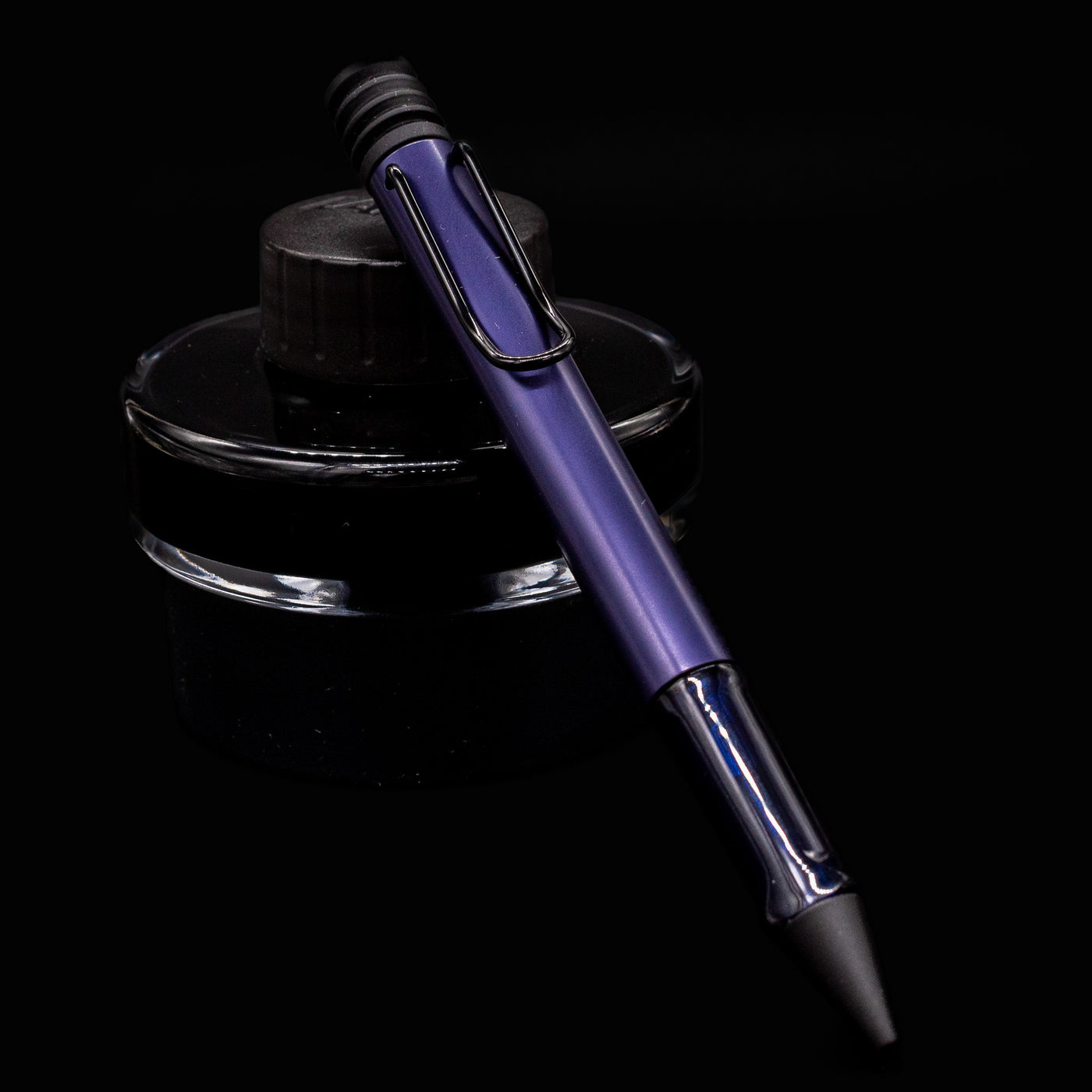 LAMY Al-Star Ballpoint Pen in Dark Dusk resting on LAMY ink bottle – sleek and modern German pen design