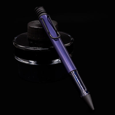 LAMY Al-Star Ballpoint Pen in Dark Dusk resting on LAMY ink bottle – sleek and modern German pen design