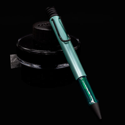 LAMY Al-Star Ballpoint Pen in Mint resting on a black LAMY ink bottle, showing modern design and matte mint finish.