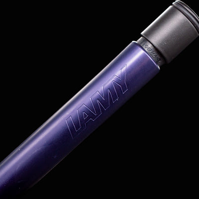 Macro close-up of the LAMY logo embossed on the barrel of the Al Star Mechanical Pencil in Dark Dusk