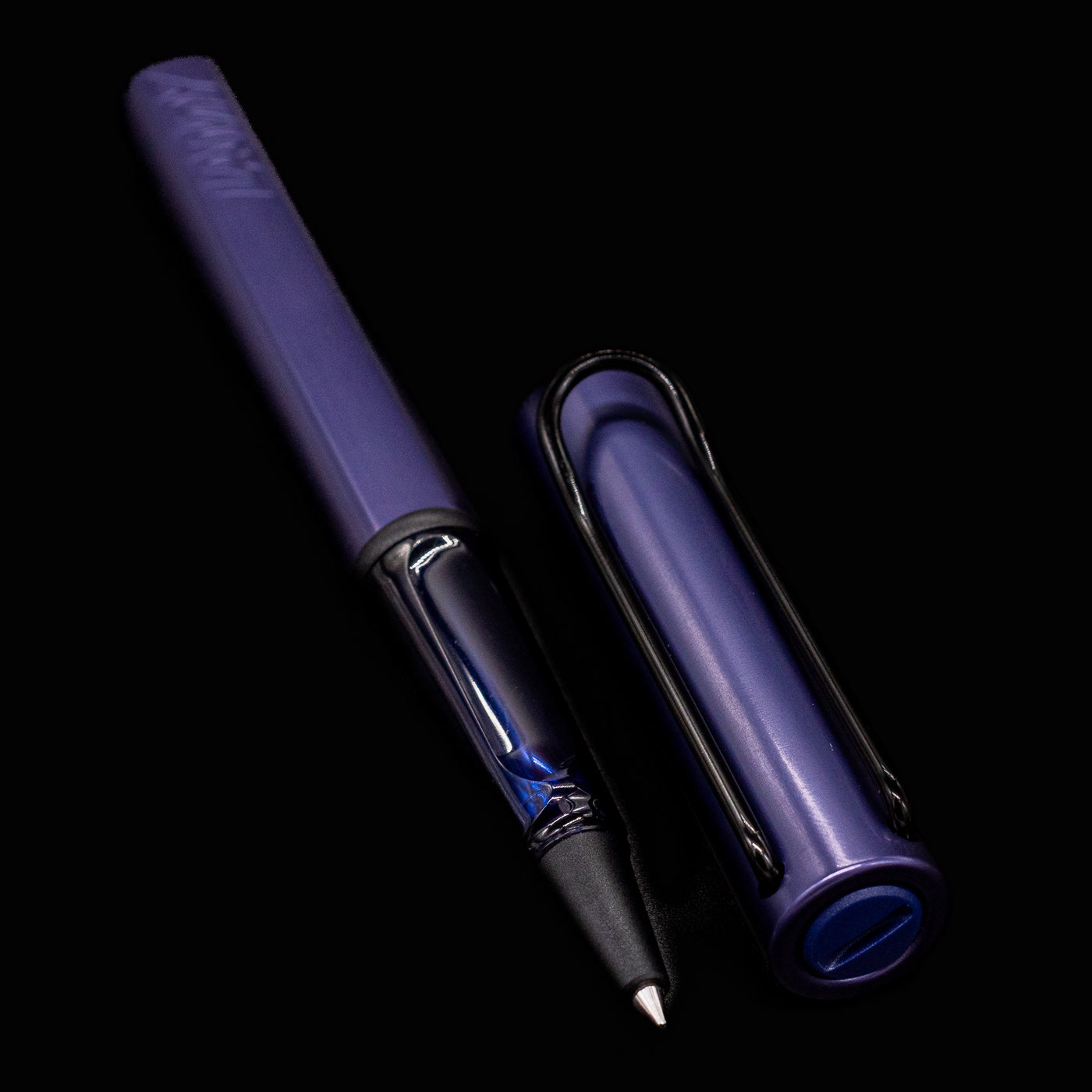 Horizontal view of the LAMY Al-Star Rollerball Pen in Dark Dusk with cap placed beside the pen
