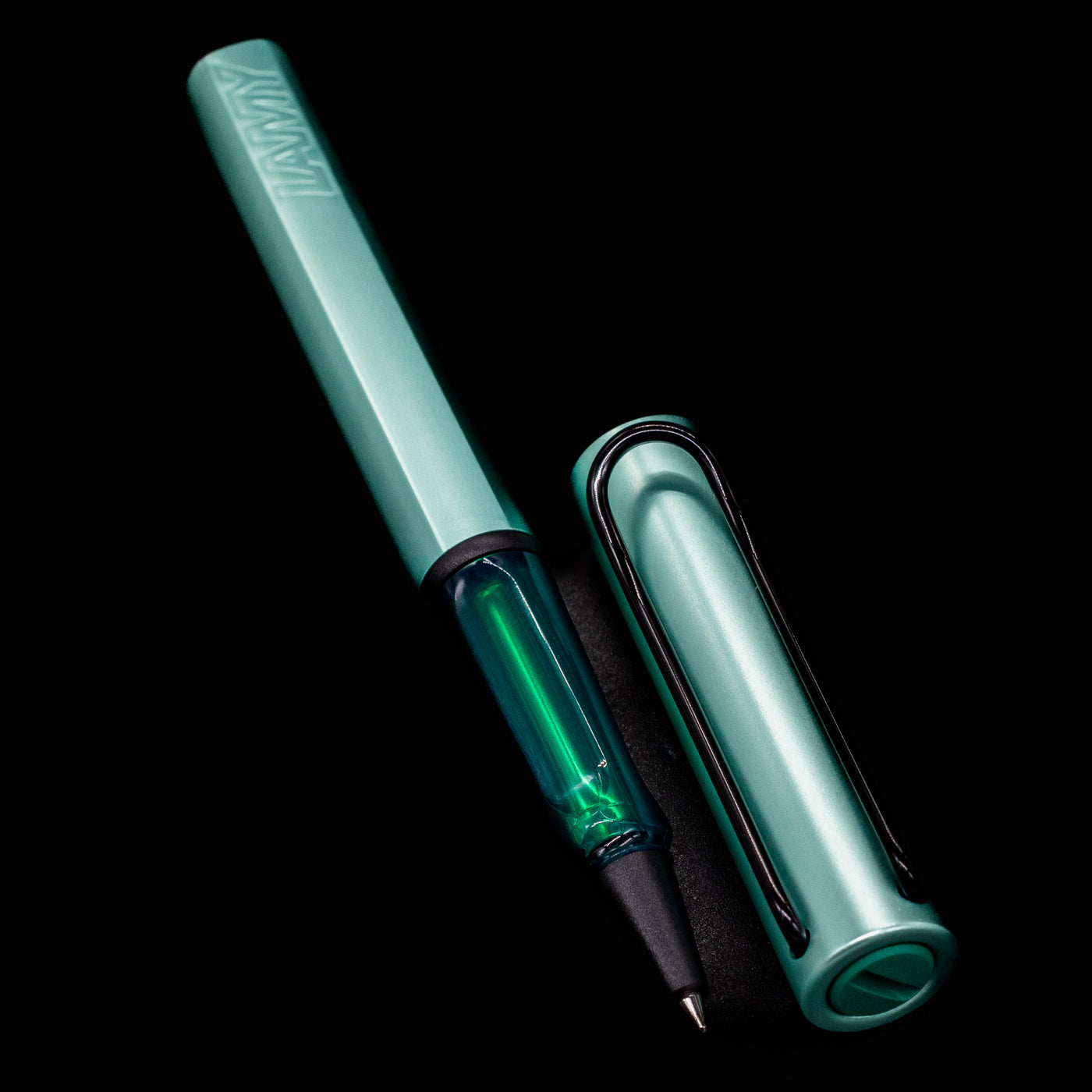 Flat lay of open LAMY Al Star Rollerball Pen in Mint with cap beside the barrel