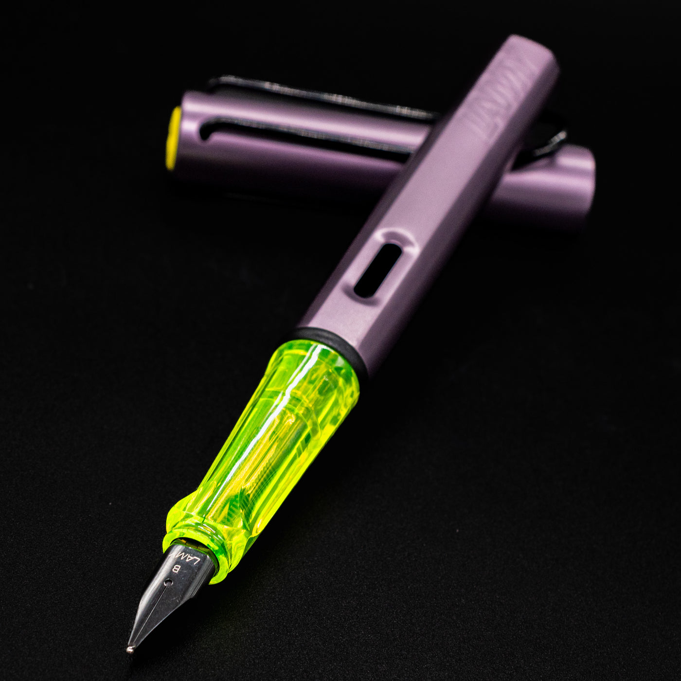 Close-up of the neon yellow transparent grip section and silver nib on the LAMY Al-Star Aubergine Fountain Pen.